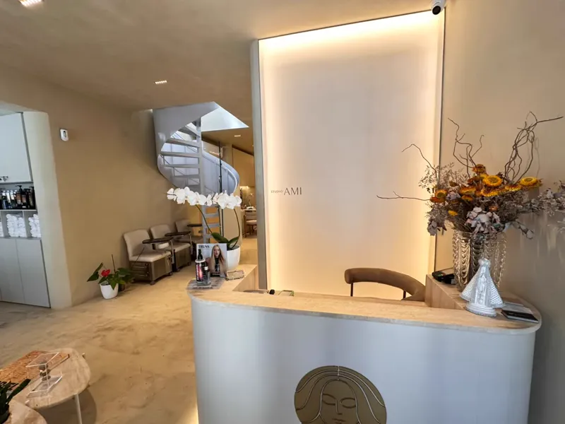 Balcão de recepção com o símbolo do Studio AMI e iluminação suave