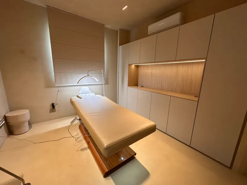 Sala de spa com maca e nichos de madeira