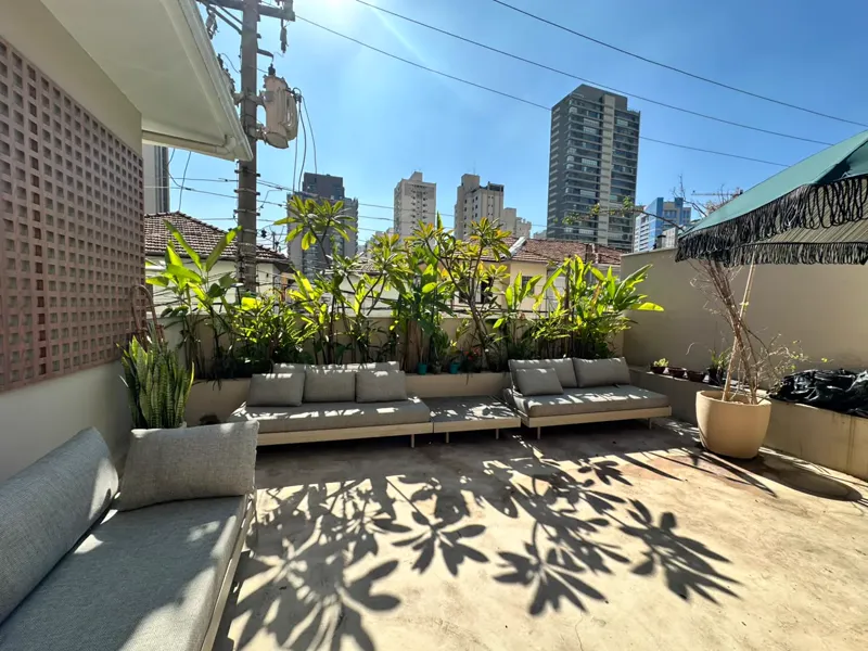 Terraço ensolarado do Studio AMI com sofás e plantas