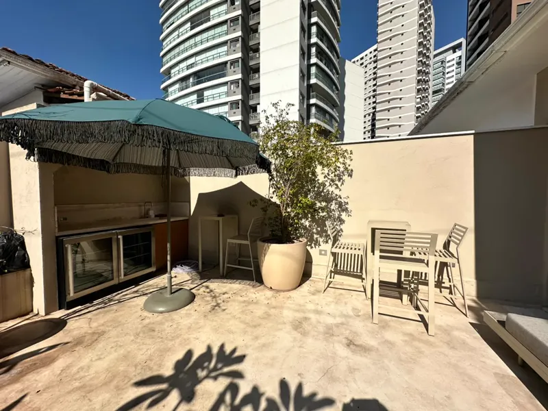 Terraço do Studio AMI com guarda-sol e plantas
